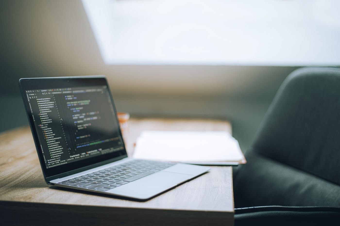 Laptop con código en un escritorio de trabajo moderno
